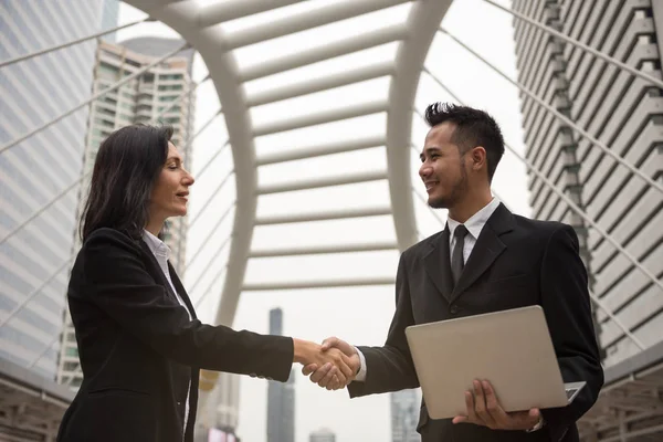 Business man and woman handshake