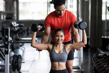 Kişisel antrenör Dumbbell 'den kadına koçluk yapıyor.