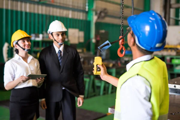 worker use remote to lift crane in factory