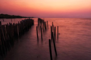 Şafakta alacakaranlık gökyüzü ile hareketli deniz manzarası