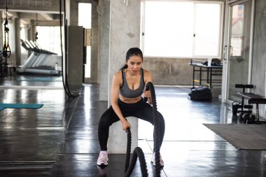 Spor salonunda Asyalı kadın halat egzersizi.