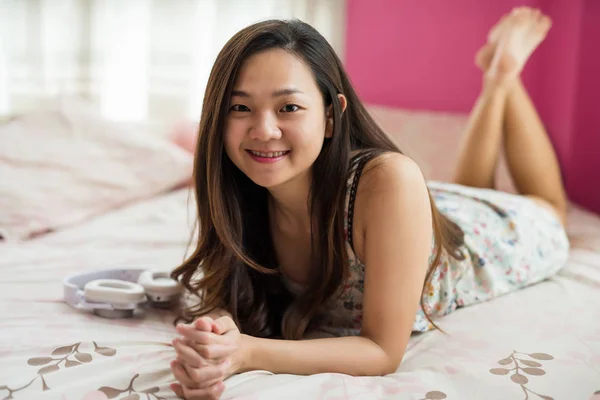 Glimlach Chinees meisje ontspannen op bed — Stockfoto