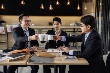 İş adamı ekibi kafede sıcak kahve içiyor.