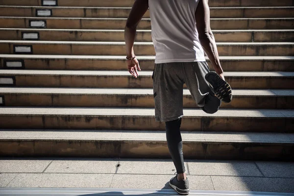 Black african man stretching leg before jogging — Stock Photo, Image