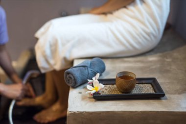Spa salonunda Tayland yağı masajından önce müşterilerin ayak yıkaması için sıcak çay. Sağlık sektörü. Masaj terapisinden önce vücut temizliği.