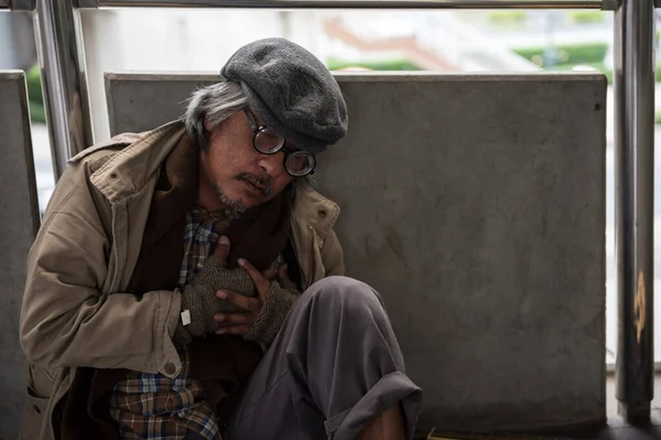 ホームレスの老人や都市の空を歩くと心臓発作から痛みを取得乞食の睡眠 貧困と病気 高齢者概念の社会問題と保険 — ストック写真
