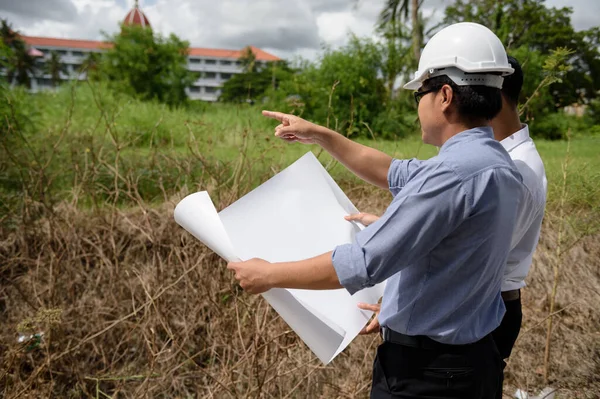 Beyaz Miğferli Kağıt Planlı Bir Mühendis Müdürü Inşaat Projesi Planı — Stok fotoğraf