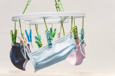 Yüz maskesi, R75 cerrahi ve kumaş maskeler, güneşli bir günde güneş ışığıyla koronavirüsten kurtulmak için yıkanmak ve kurumak. Küresel arz eksikliği veya tedarik eksikliği nedeniyle covid-19 hastalığını önlemek için araçların yeniden kullanılması veya geri dönüştürülmesi.
