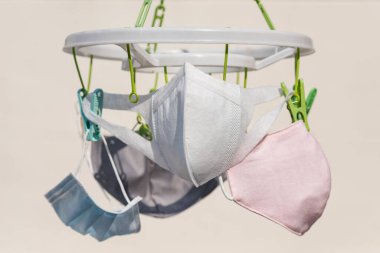 Yüz maskesi, PM2.5, R75 cerrahi, ve kumaş maskeler, güneşli bir günde güneş ışığından koronavirüsten kurtulmak için yıkanır ve kurulanır. Küresel eksiklik veya tedarik eksikliği nedeniyle covid-19 hastalığını önlemek için yeniden kullan veya geri dönüştür