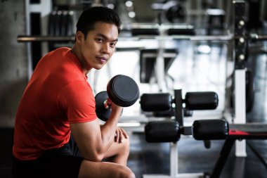 Kas Asyalı adam spor salonunda halterle tek başına egzersiz yapıyor. Vücut geliştirme ve kovid 19 veya koronavirüs sırasında sağlıklı. Sosyal uzaklık, karantina, evden çalışmak, evde kalmak..