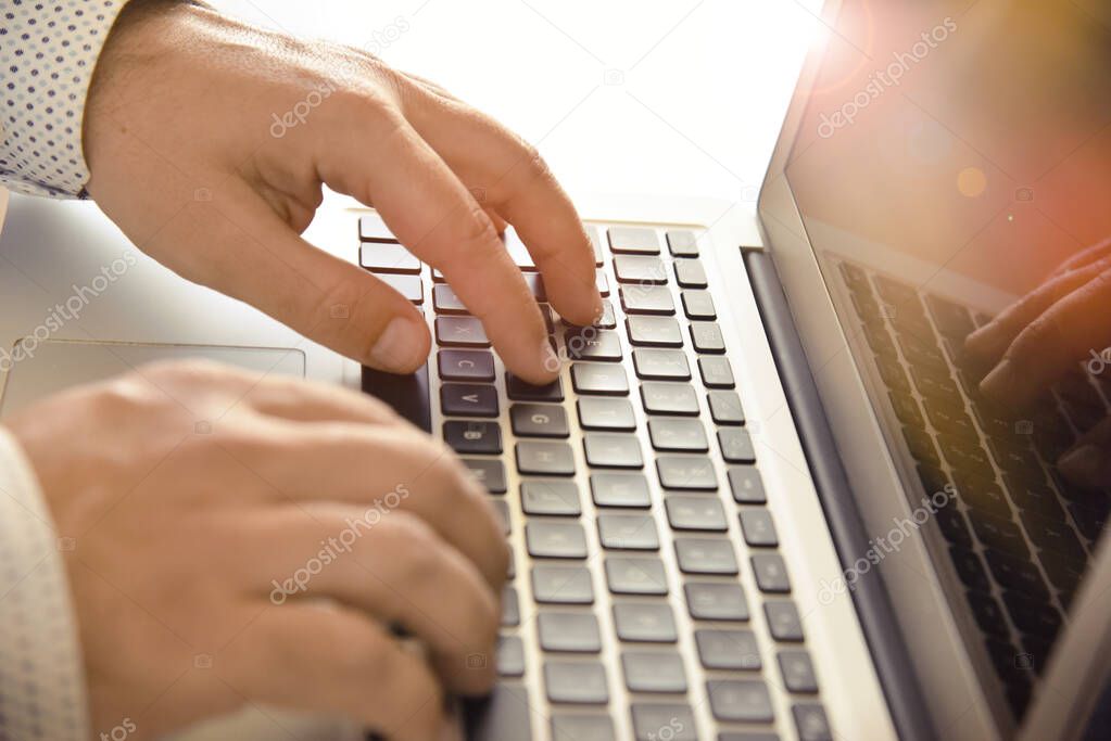 Closeup of mans hands typing on laptop keyboard. Concept for background, website banner, poster, presentation templates, social media, advertising and printed materials. 