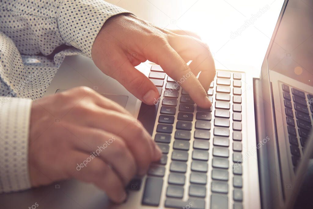 Closeup of a businessman working on a laptop. Concept for background, website banner, poster, presentation templates, social media, advertising and printed materials. 