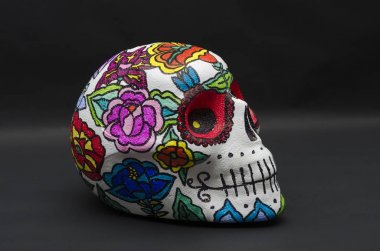 Strafor kafatası el boyalı, siyah arka plan karşı Meksika çiçeklerle süslenmiş