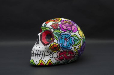 Strafor kafatası el boyalı, siyah arka plan karşı Meksika çiçeklerle süslenmiş