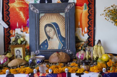 Oaxaca, Oaxaca, Meksika - 2 Kasım 2017: Geleneksel Meksikalı ÖIüler Günü sunak ile Virgin Guadalupe, sarı çiçekler, ekmek ve meyve Oaxaca, Meksika için resmini sunuyor. Şenlik Meksika 31 Ekim, Kasım kutladı