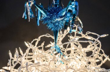 Siyah arka plan üzerinde Noel ve yeni yıl için dekorasyon olarak mavi Pinata'yı ve Noel ışıkları