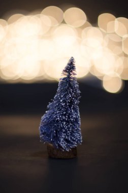Küçük Noel ağacı bokeh arka plana dayanır. Küçük Noel ağacı ışıkları ile