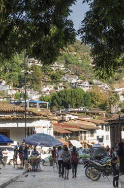Valle De Bravo, Meksika-17 Şubat 2018: Valle de Bravo, Meksika araçları ile tipik bir sokakta ve güneşli bir gün insanlarda görünümünü