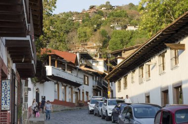 Valle De Bravo, Meksika-17 Şubat 2018: Valle de Bravo, Meksika tipik bir sokakta arabalar ve alacakaranlıkta insanlar görünümünü