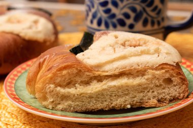 Küçük bir tabakta bir dilim geleneksel epifani pastası ve bulanık bir bardak.
