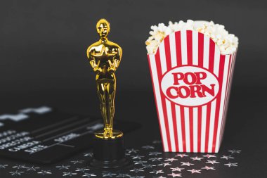 Xalapa, Veracruz, Meksika - 31 Ocak 2020: Plastik Oscar ödülü, klaket, klasik patlamış mısır kutusu ve siyah arka planda gümüş yıldızlar