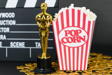 Xalapa, Veracruz, Meksika - 31 Ocak 2020: Clapboard, Oscar ödülü, klasik patlamış mısır kutusu ve siyah arka planda altın yıldızlar