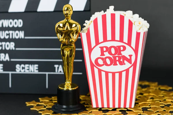 Xalapa, Veracruz, Meksika - 31 Ocak 2020: Clapboard, Oscar ödülü, klasik patlamış mısır kutusu ve siyah arka planda altın yıldızlar
