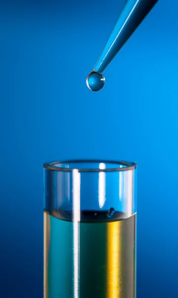 Laboratoriet pipett med en droppe av ämne över provrör — Stockfoto
