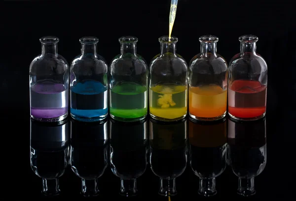 Apothecary, laboratory bottles with colored liquid and pipette w — Stock Photo, Image