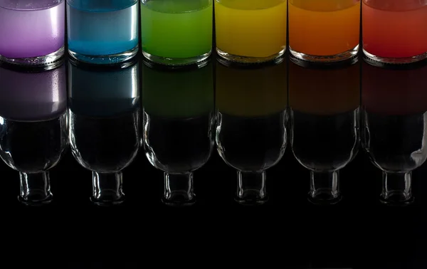Аптекарь, лабораторные бутылки с цветной жидкостью с отражением — стоковое фото