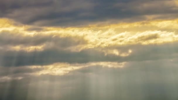 Un rayo de luz solar rompiendo nubes oscuras — Vídeos de Stock
