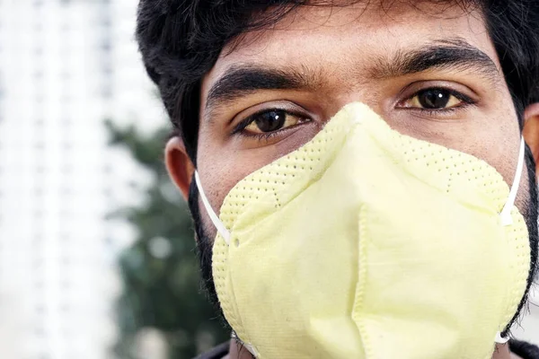 Indian man in yellow protective mask