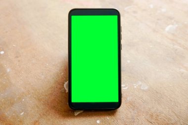 Yeşil ekranlı akıllı telefonu tutan.