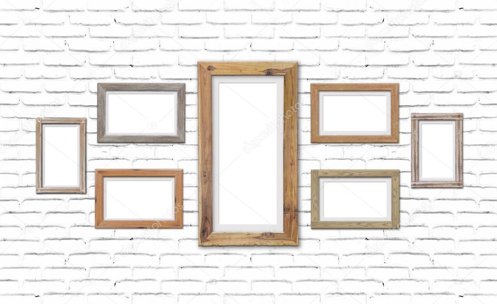 Collection of brown wood frames on brick wall. For interiors decor mockup