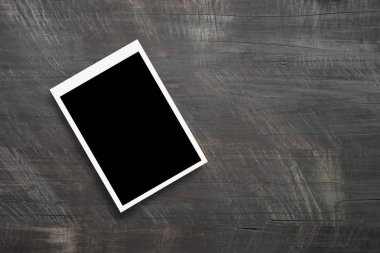 Ahşap masa arkasındaki boş fotoğraf çerçevelerinin üst görünümü.