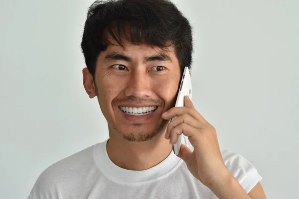 Un macho está hablando por teléfono con la cara sonriente — Foto de Stock
