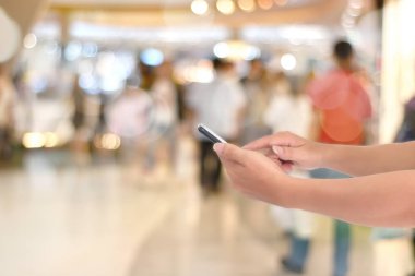 Yan görüş, El 'in bulanık ışık arka planında akıllı telefon kullanması. İş ve teknoloji, internet kavramı