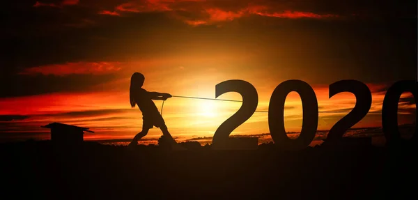 落日背景下的女孩拉绳号码2020的轮廓 新年快乐假期的概念 — 图库照片
