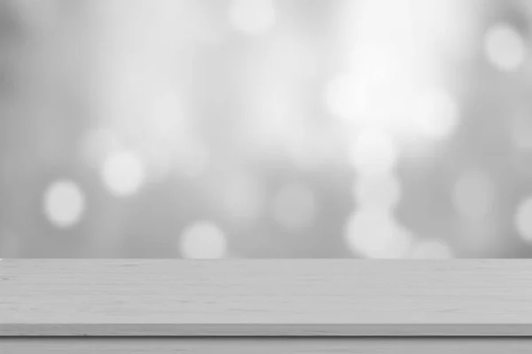Beyaz ahşap masa üstü, bulanık beyaz bokeh ışıklı arka plan. Ürün görüntüleme, afiş veya modelleme için boş ahşap raf.