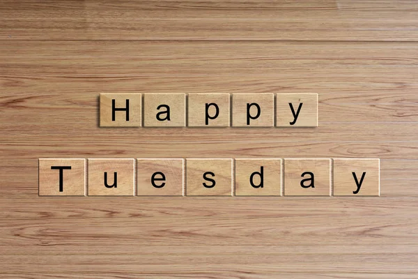 Happy Tuesday word written on wood block. Message text on wooden table for backdrop design.