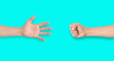 Mavi zeminde taş-kağıt-makas oynayan iki el.