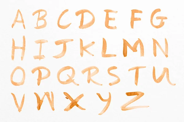 字母基础字母在白纸背景上被分离出来 是用咖啡染色写的 — 图库照片