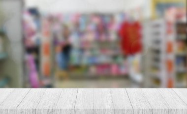 Boş beyaz ahşap masa ya da bulanık deponun arka planında raflar. Ürün gösterimi, afiş, maket.