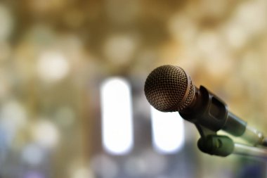 Sahnedeki mikrofonun yakın plan görüntüsü bokeh arkaplana karşıdır.