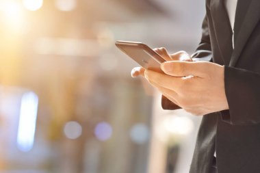 Bir cep telefonu kullanarak iş adamına yaklaş. Cep telefonlu genç işletme yöneticisi .