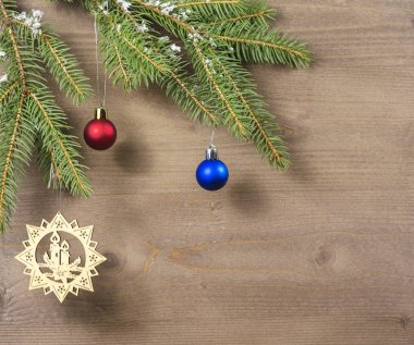 Karda Noel ağacı ve tahta arka planda yeni yıl oyuncakları.