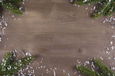 Karda Noel ağacı ve tahta arka planda yeni yıl oyuncakları.