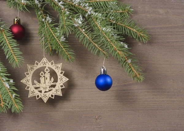 Karda Noel ağacı ve tahta arka planda yeni yıl oyuncakları.