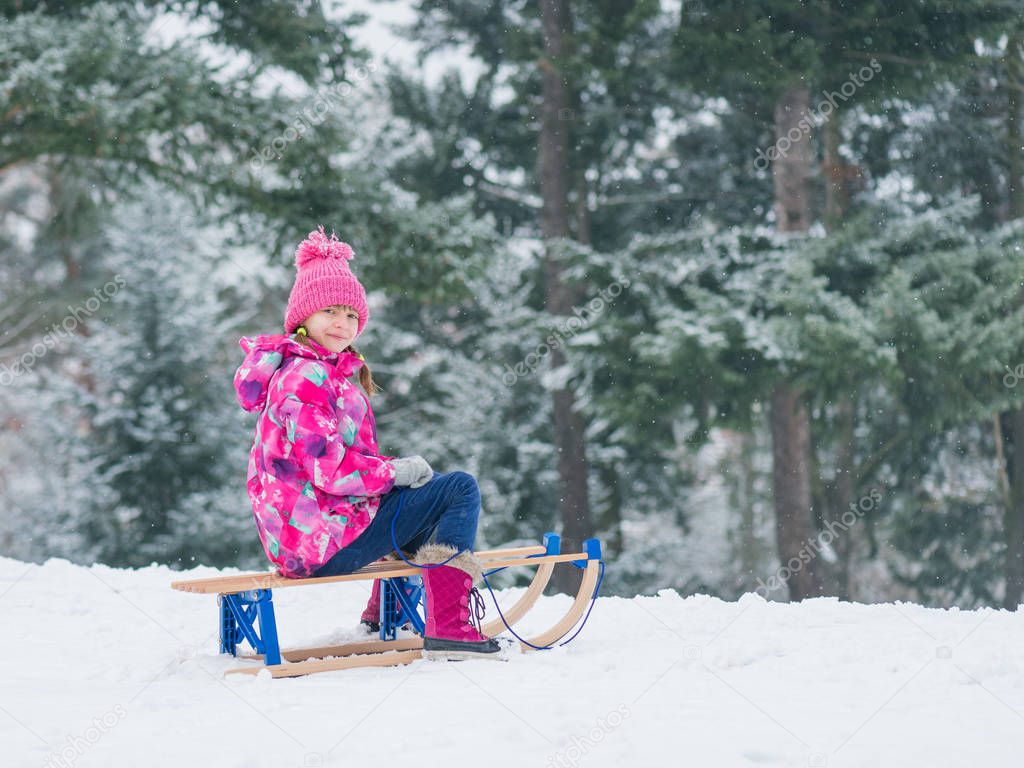 Child play in snow with sled