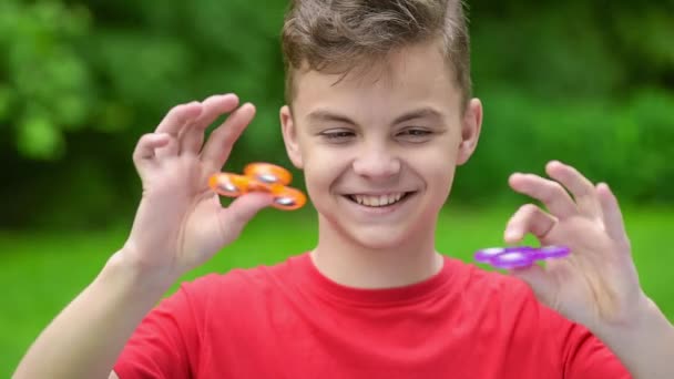 Teen boy with spinner in park — Stock Video